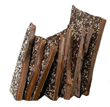 Load image into Gallery viewer, Close up of several pieces of toasted coconut brittle candy stacked.
