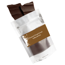 Load image into Gallery viewer, Brittle pieces spilling out of 3oz sized bag with brown label stating “Toasted Gingerbread Toffee Brittle” and NeoCocoa logo. On a white background. 