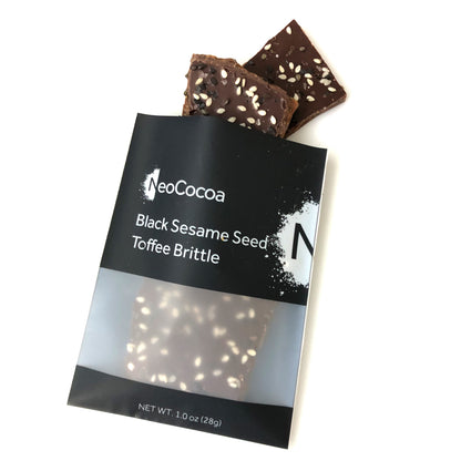 1 oz of sesame brittle pouring out of black and white cellophane bag with label stating “Black Sesame Seed Toffee Brittle” and NeoCocoa logo, 1oz (28g)