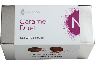 2 dimensional rectangle box with a label wrapped around the box stating, “Caramel Duet” with NeoCocoa logo. Can see some of the side of the label with image of a dark salted caramel truffle and a milk salted caramel truffle.  