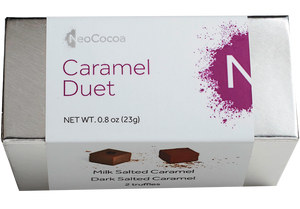 2 dimensional rectangle box with a label wrapped around the box stating, “Caramel Duet” with NeoCocoa logo. Can see some of the side of the label with image of a dark salted caramel truffle and a milk salted caramel truffle.  