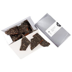 2 dimensional angle of opened 8oz box with title of “Black Sesame Seed Toffee Brittle” with NeoCocoa logo and 8oz pile candy pieces inside the box bottom. 3 pieces of candy spilling out.