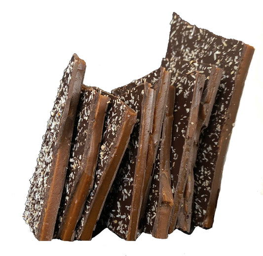 Close up of several pieces of toasted coconut brittle candy stacked.